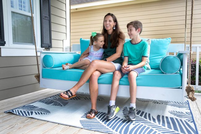 Mother with two children relaxing on porch swing sofa