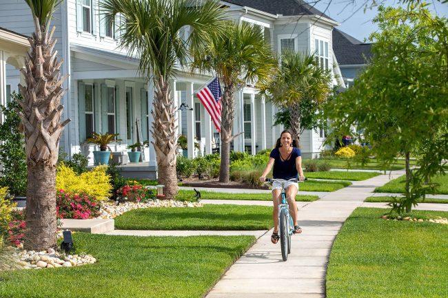 Woman riding a bike on the sidewalk